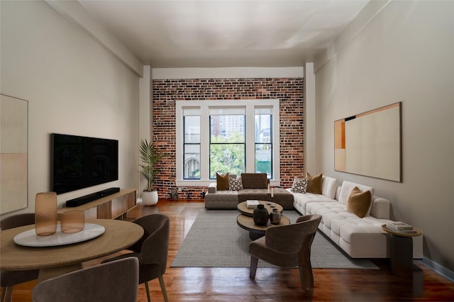 living room with hardwood / wood-style floors and brick wall