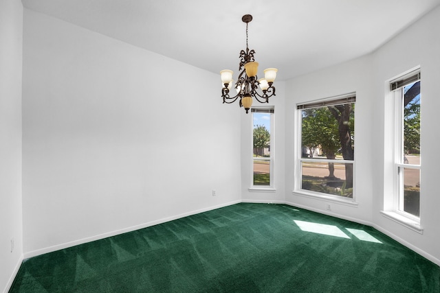 carpeted empty room featuring a chandelier