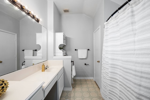 bathroom featuring vanity, lofted ceiling, and toilet