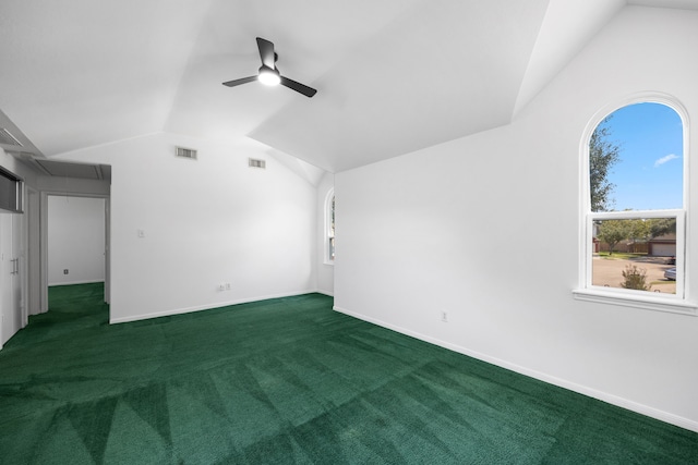 interior space with ceiling fan, vaulted ceiling, and dark carpet