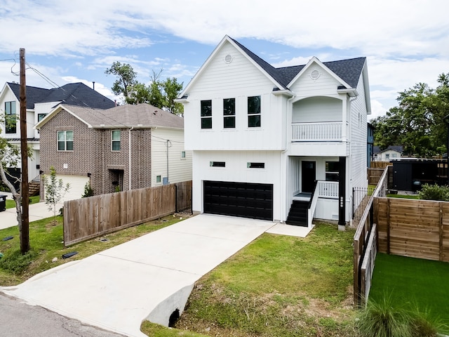 view of front facade with a front lawn, a balcony, and a garage