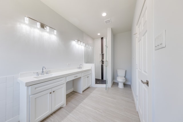 bathroom with walk in shower, vanity, and toilet