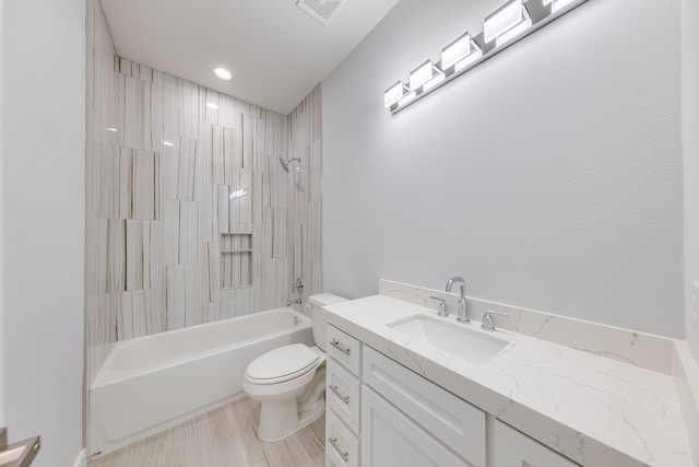 full bathroom featuring tiled shower / bath combo, vanity, and toilet