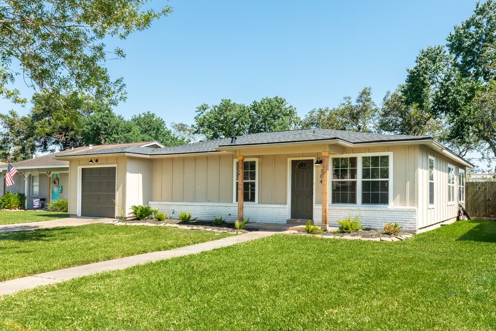 ranch-style home with a garage and a front lawn