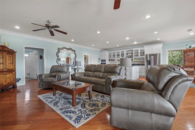 living room featuring dark hardwood / wood-style floors, ornamental molding, and ceiling fan