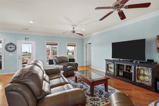 living room featuring light hardwood / wood-style floors, ornamental molding, and ceiling fan