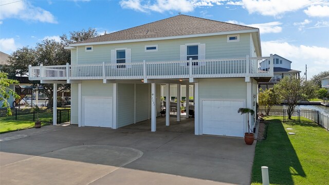 rear view of house with a garage, a lawn, and a carport