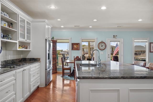 kitchen featuring white cabinets, sink, a kitchen island with sink, stainless steel fridge with ice dispenser, and hardwood / wood-style floors