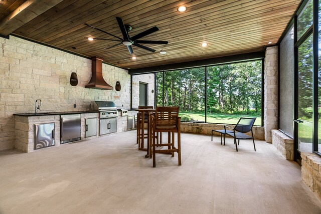 exterior space with ceiling fan, sink, a grill, and exterior kitchen