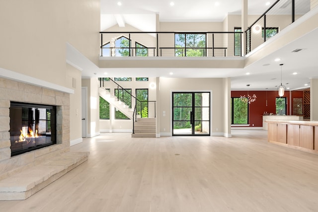23560 High Meadow Estates Dr, Montgomery, TX 77316 - unfurnished living room with a high ceiling, a fireplace, light wood-style floors, baseboards, and stairs