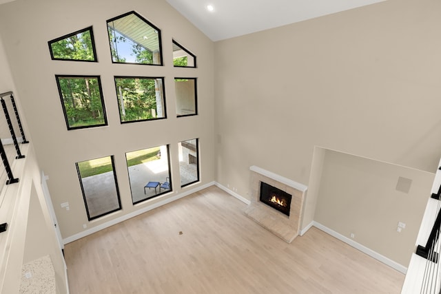 23560 High Meadow Estates Dr, Montgomery, TX 77316 - unfurnished living room with high vaulted ceiling, a tiled fireplace, light wood-style flooring, baseboards, and recessed lighting
