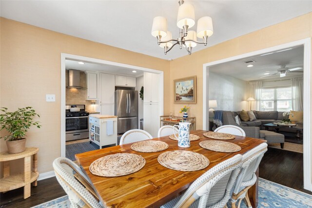 dining space with ceiling fan with notable chandelier and dark hardwood / wood-style floors