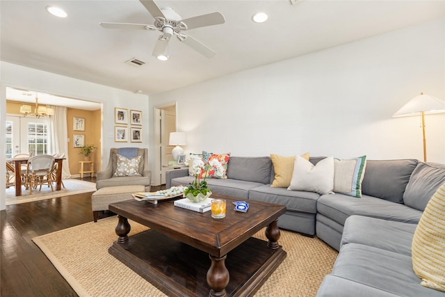 living room with wood-type flooring, ceiling fan with notable chandelier, and french doors