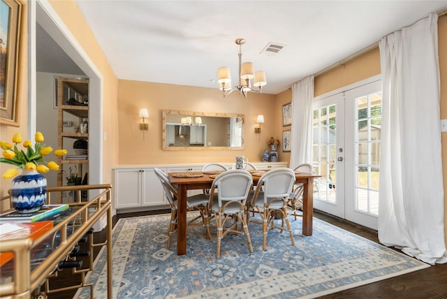 dining room with a notable chandelier, dark wood-type flooring, and french doors