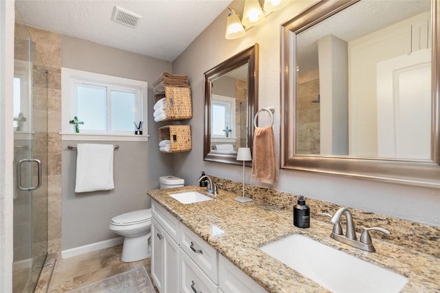 bathroom featuring vanity, a shower with shower door, a textured ceiling, and toilet