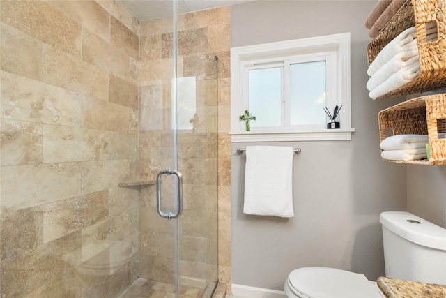 bathroom with a shower with shower door and toilet