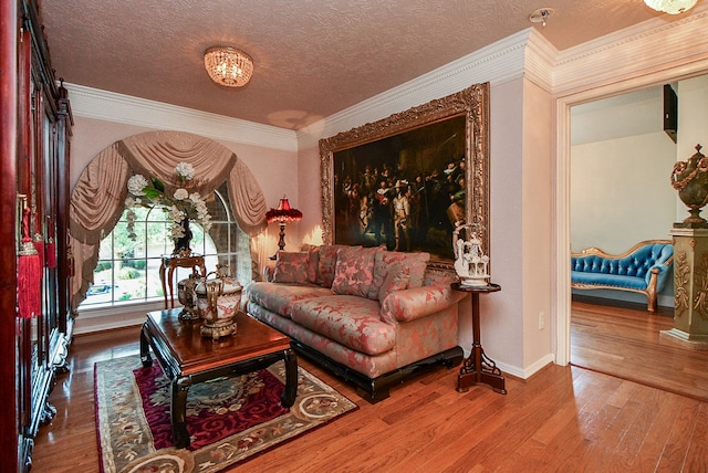 sitting room with ornamental molding, hardwood / wood-style floors, and a textured ceiling