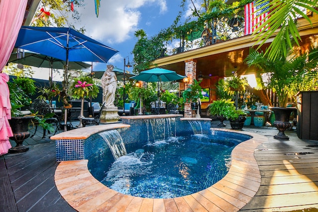 view of swimming pool with a jacuzzi, a wooden deck, and pool water feature