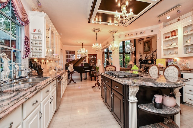 kitchen featuring stainless steel appliances, light stone countertops, decorative light fixtures, and a wealth of natural light