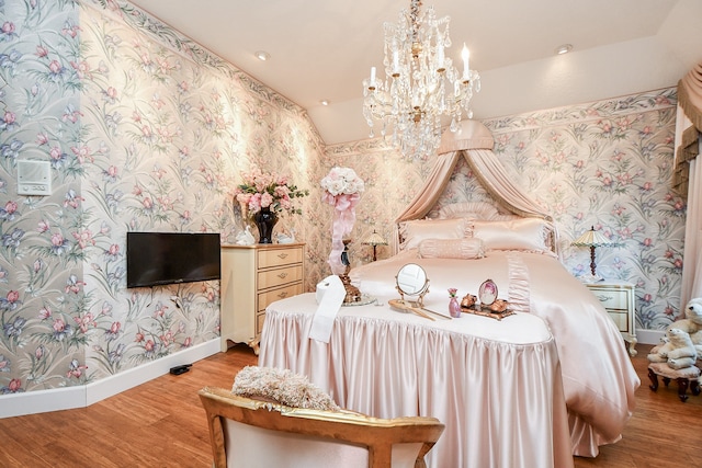 bedroom featuring lofted ceiling, light hardwood / wood-style floors, and a chandelier