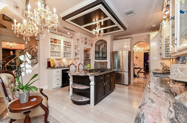 kitchen featuring dark brown cabinetry, stainless steel appliances, dark stone countertops, crown molding, and hanging light fixtures