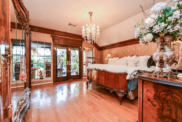 unfurnished bedroom featuring access to outside, french doors, wood-type flooring, an inviting chandelier, and vaulted ceiling