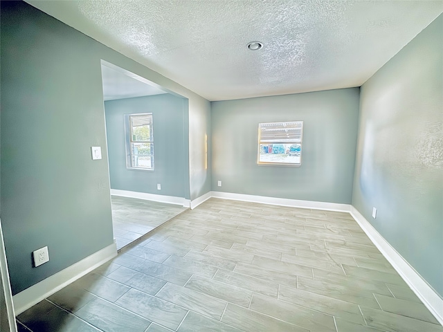 spare room featuring a textured ceiling and light wood-type flooring