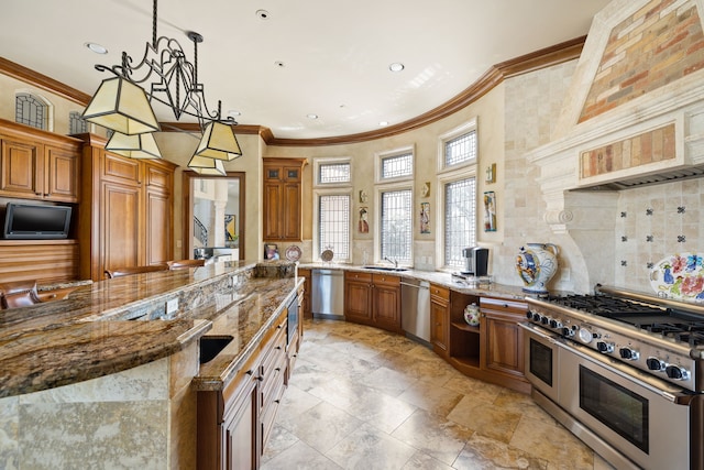 kitchen with light stone counters, stainless steel appliances, crown molding, sink, and decorative light fixtures