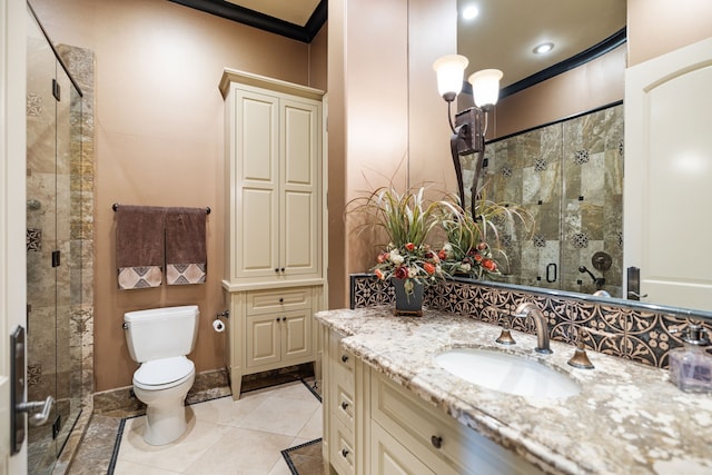 bathroom with tile patterned floors, ornamental molding, vanity, toilet, and a shower with shower door