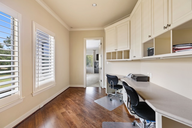 home office with built in desk, a healthy amount of sunlight, dark hardwood / wood-style floors, and ornamental molding