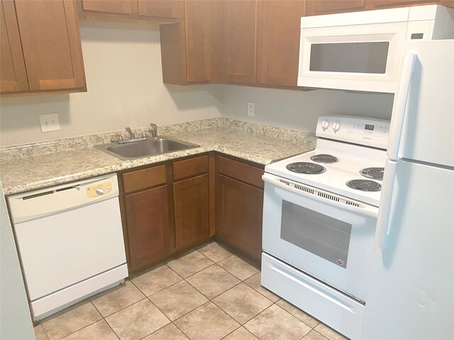 kitchen featuring white appliances, sink, and light tile patterned floors