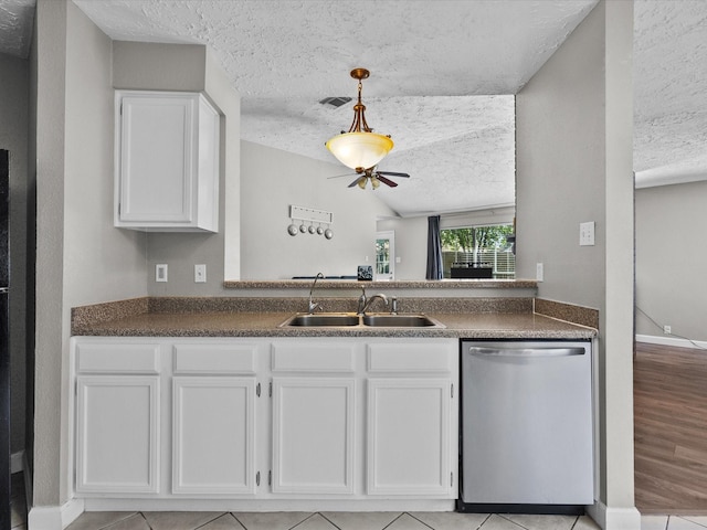 kitchen with white cabinetry, sink, stainless steel dishwasher, and a textured ceiling