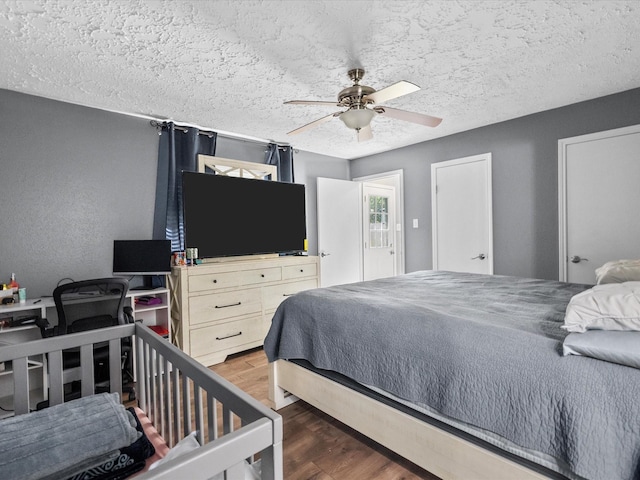 bedroom featuring a textured ceiling, dark hardwood / wood-style floors, and ceiling fan