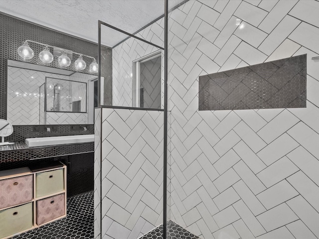 bathroom with tiled shower and vanity