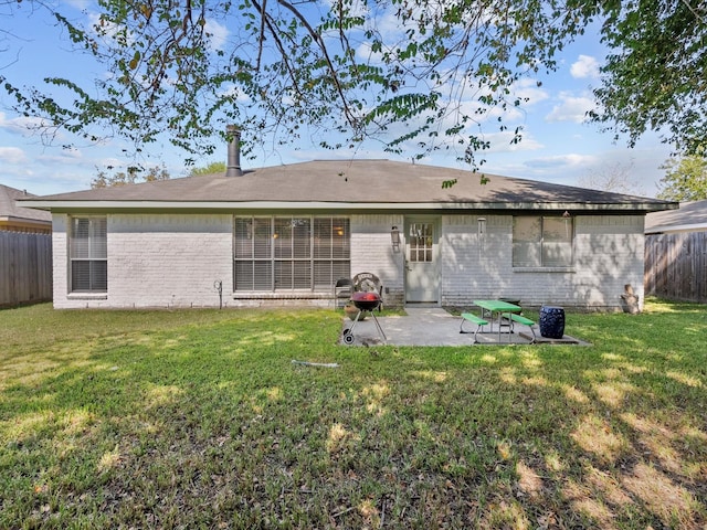 back of house featuring a lawn and a patio area