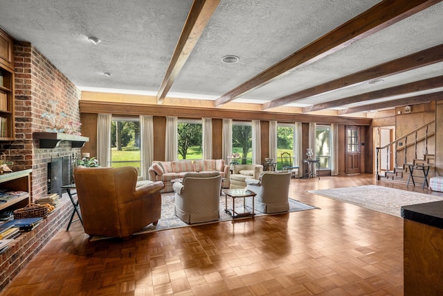 living room featuring plenty of natural light, parquet flooring, a brick fireplace, and a textured ceiling