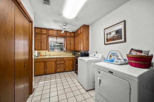 laundry area with ceiling fan, sink, light tile patterned flooring, cabinets, and washing machine and clothes dryer