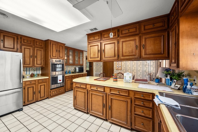 kitchen featuring light tile patterned floors, ceiling fan, sink, and stainless steel appliances