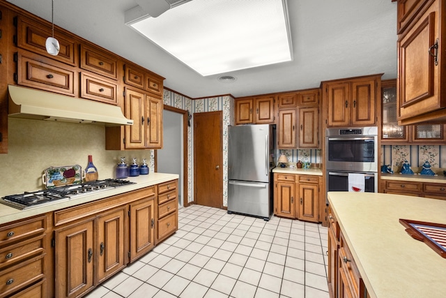 kitchen featuring stainless steel appliances, hanging light fixtures, and light tile patterned floors