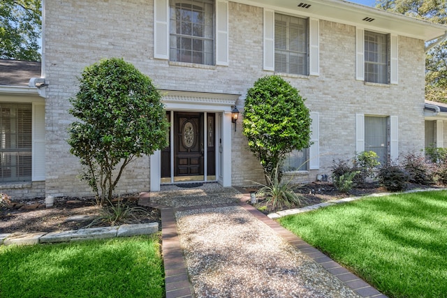 property entrance featuring a lawn