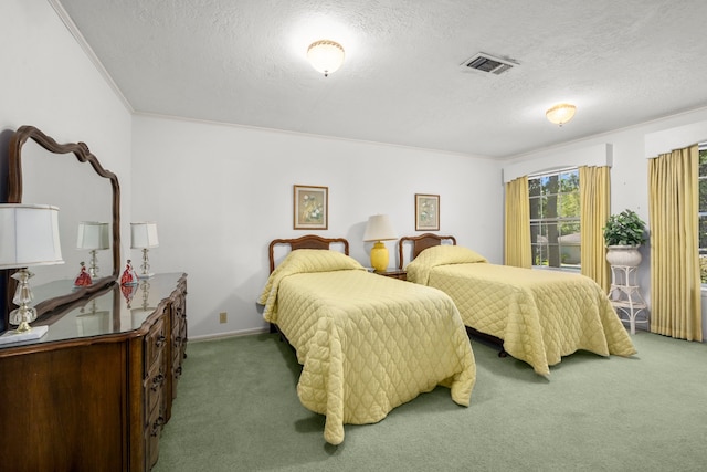 bedroom with crown molding, carpet floors, and a textured ceiling