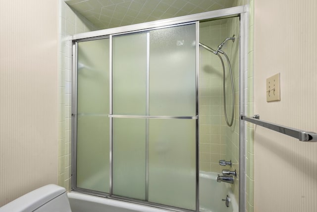 bathroom with shower / bath combination with glass door and toilet