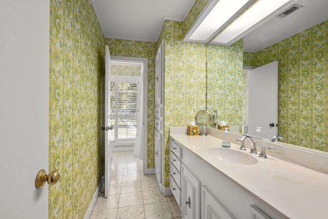 bathroom with vanity, ornamental molding, and tile patterned floors