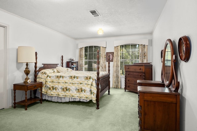 carpeted bedroom with ornamental molding and a textured ceiling