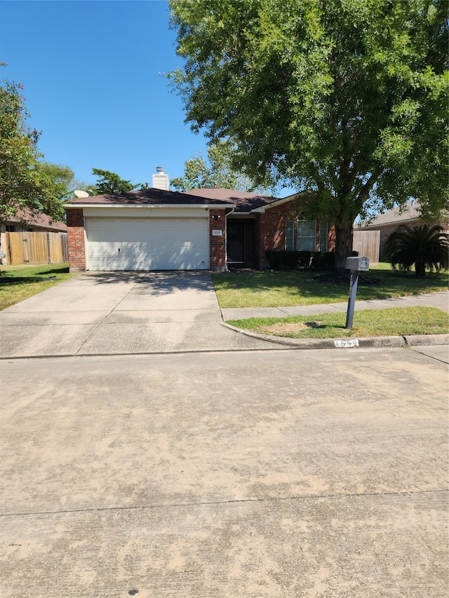 ranch-style house with a garage and a front lawn