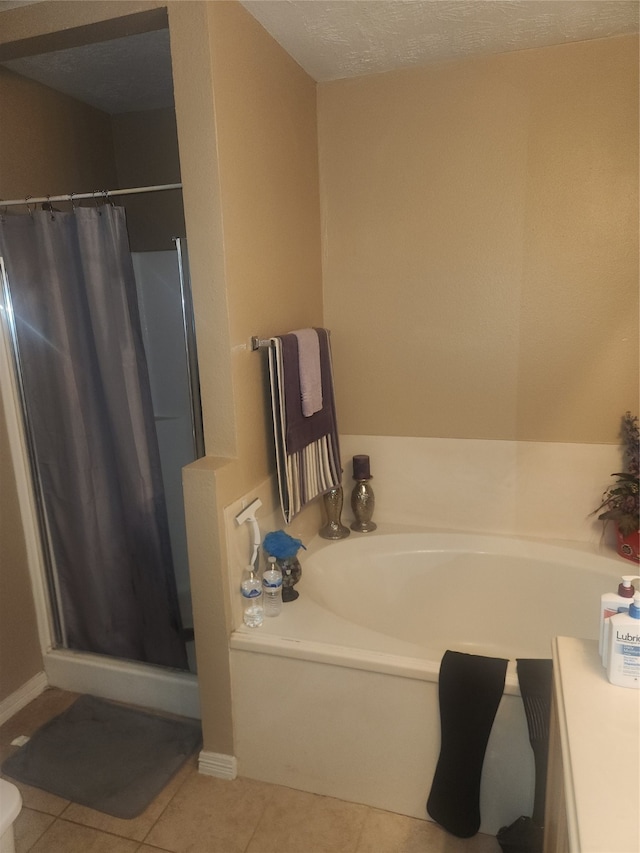 bathroom featuring tile patterned flooring, separate shower and tub, and a textured ceiling