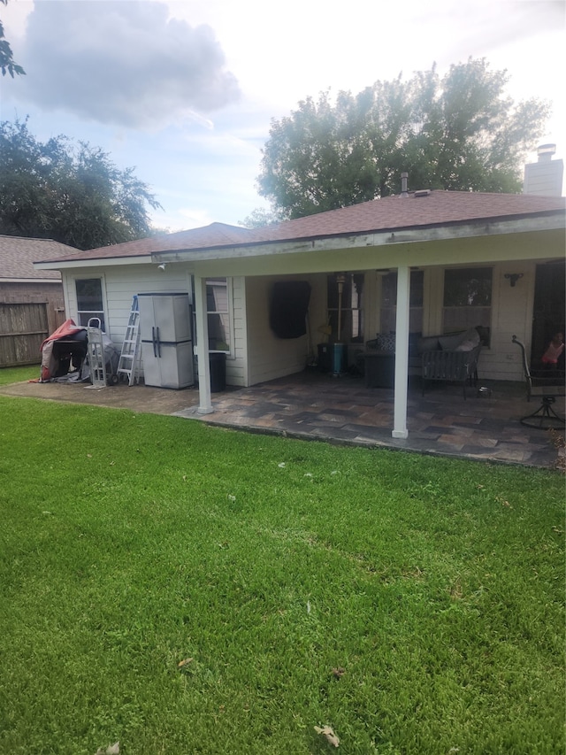 back of house featuring a patio area and a lawn