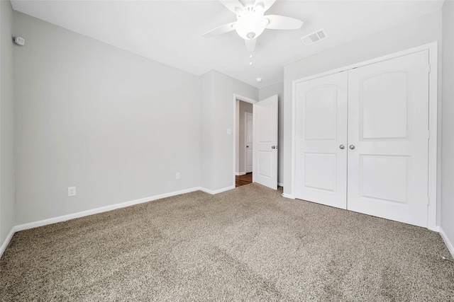 unfurnished bedroom with carpet, ceiling fan, and a closet