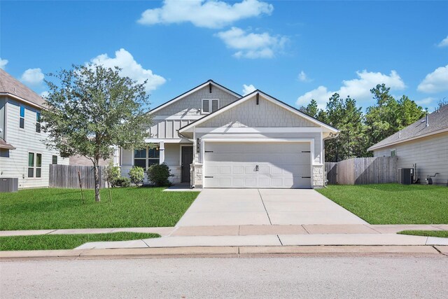 view of front of house with central AC, a garage, and a front lawn