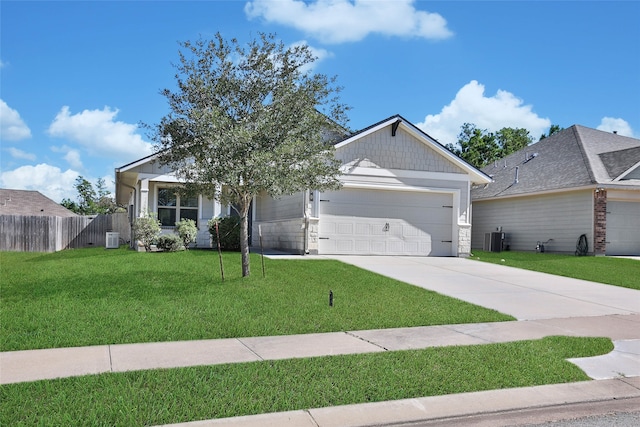 view of front of house featuring cooling unit, a front yard, and a garage